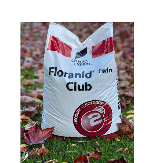 Rasendünger im 25kg Sack für den Herbst mit Laub im Hintergrund